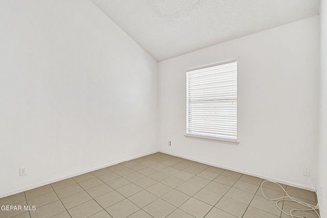 7145 Golden Hawk Dr, El Paso, TX 79912 - spare room with vaulted ceiling, light tile patterned flooring, and a textured ceiling