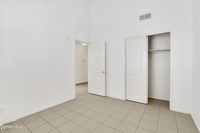 7145 Golden Hawk Dr, El Paso, TX 79912 - unfurnished bedroom featuring light tile patterned floors, a high ceiling, baseboards, and a closet