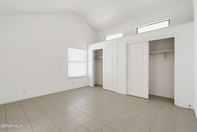 7145 Golden Hawk Dr, El Paso, TX 79912 - unfurnished bedroom with two closets, light tile patterned floors, multiple windows, and high vaulted ceiling
