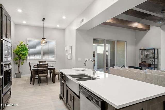 2212 Mike Price Dr, El Paso, TX 79938 - kitchen with appliances with stainless steel finishes, light countertops, light wood-style flooring, a kitchen island with sink, and plenty of natural light