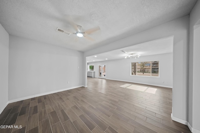 10950 Jo Way, Socorro, TX 79927 - unfurnished living room with a ceiling fan, a textured ceiling, wood finished floors, and baseboards
