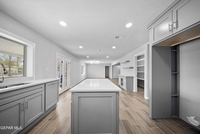 10950 Jo Way, Socorro, TX 79927 - kitchen featuring gray cabinets, a center island, a sink, french doors, and recessed lighting