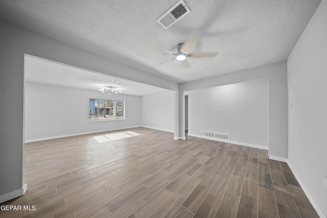 10950 Jo Way, Socorro, TX 79927 - unfurnished living room with a ceiling fan, wood finished floors, baseboards, a textured ceiling, and a chandelier