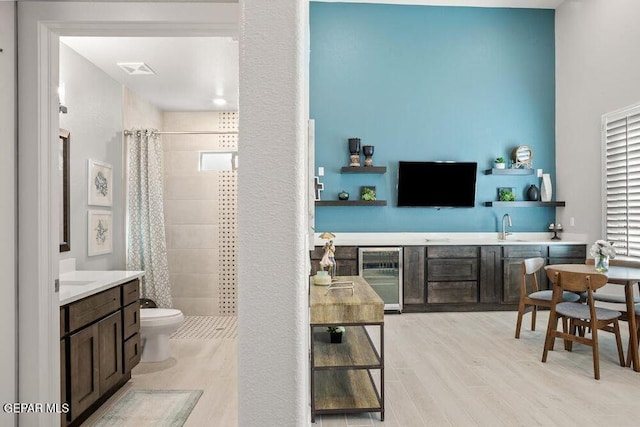 2228 Mike Price Dr, El Paso, TX 79938 - living area featuring wine cooler, bar with sink, and light wood-style flooring