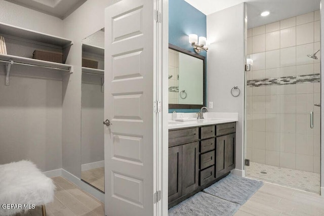 2228 Mike Price Dr, El Paso, TX 79938 - full bath with a stall shower, double vanity, a walk in closet, and recessed lighting