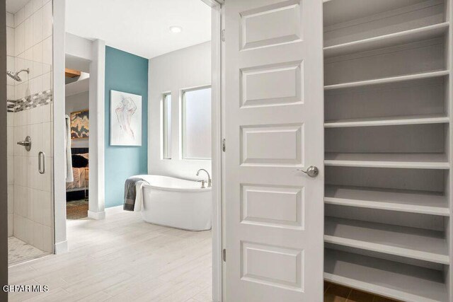 2228 Mike Price Dr, El Paso, TX 79938 - ensuite bathroom featuring a shower stall, a freestanding tub, and wood finished floors