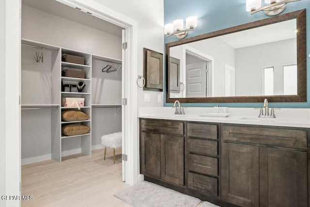2228 Mike Price Dr, El Paso, TX 79938 - full bath with double vanity, a chandelier, wood finished floors, and a spacious closet
