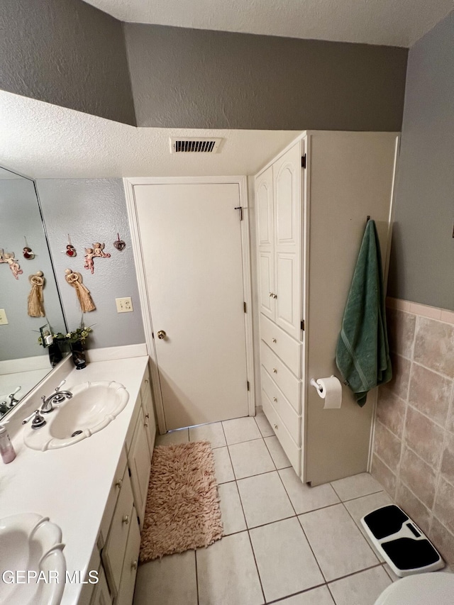 16899 Old Butterfield Trl, El Paso, TX 79938 - full bathroom with double vanity, tile patterned floors, a textured wall, and a textured ceiling