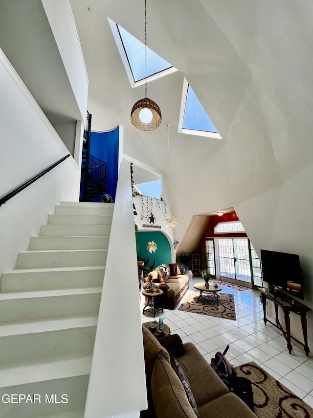 16899 Old Butterfield Trl, El Paso, TX 79938 - living area featuring a skylight, a towering ceiling, tile patterned floors, and stairs