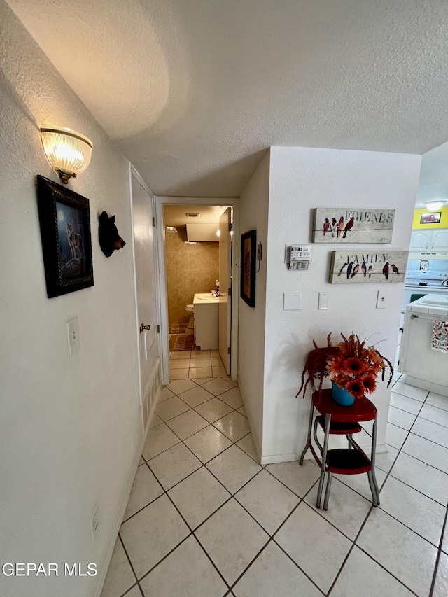 16899 Old Butterfield Trl, El Paso, TX 79938 - hallway featuring a textured ceiling and light tile patterned floors