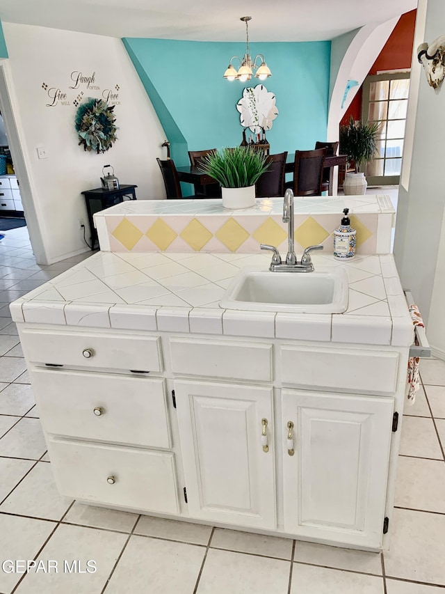 16899 Old Butterfield Trl, El Paso, TX 79938 - kitchen featuring light tile patterned floors, white cabinets, a chandelier, tile counters, and decorative light fixtures