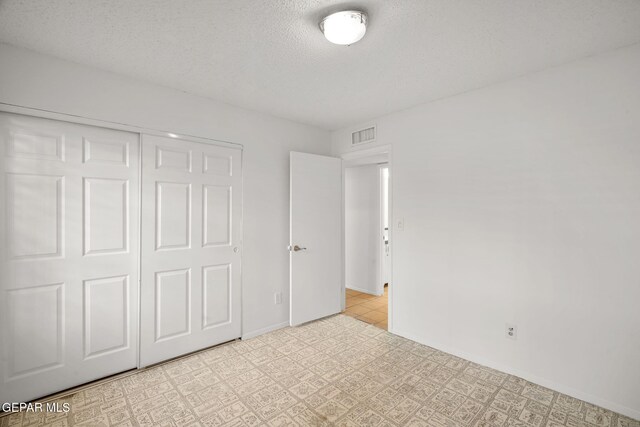 10601 Groverock Ct, El Paso, TX 79935 - unfurnished bedroom featuring a textured ceiling, a closet, and baseboards