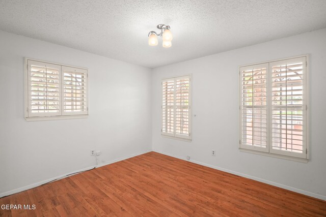 10601 Groverock Ct, El Paso, TX 79935 - spare room with plenty of natural light, wood finished floors, a textured ceiling, and baseboards