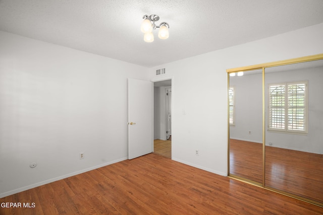 10601 Groverock Ct, El Paso, TX 79935 - unfurnished bedroom featuring wood finished floors, a closet, baseboards, and a chandelier
