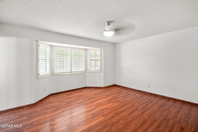 10601 Groverock Ct, El Paso, TX 79935 - spare room with wood finished floors, ceiling fan, a textured ceiling, and baseboards