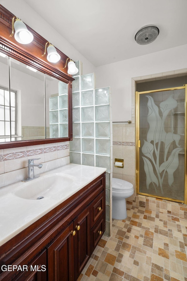 10601 Groverock Ct, El Paso, TX 79935 - full bath featuring tile walls, a stall shower, vanity, and toilet