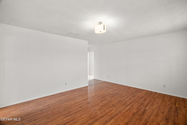 10601 Groverock Ct, El Paso, TX 79935 - unfurnished room featuring wood finished floors, a textured ceiling, and baseboards