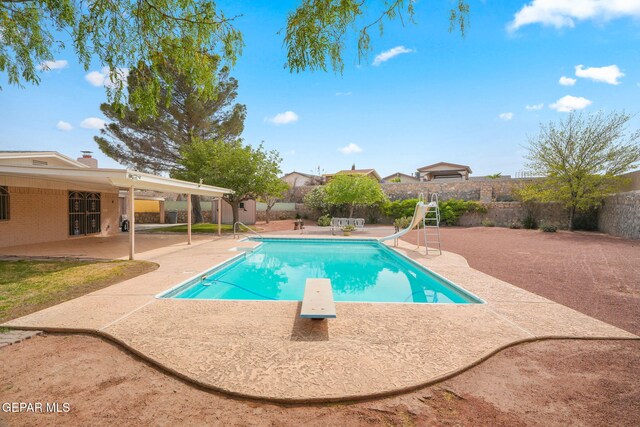 10601 Groverock Ct, El Paso, TX 79935 - view of pool with a patio area, a water slide, a fenced backyard, and a diving board