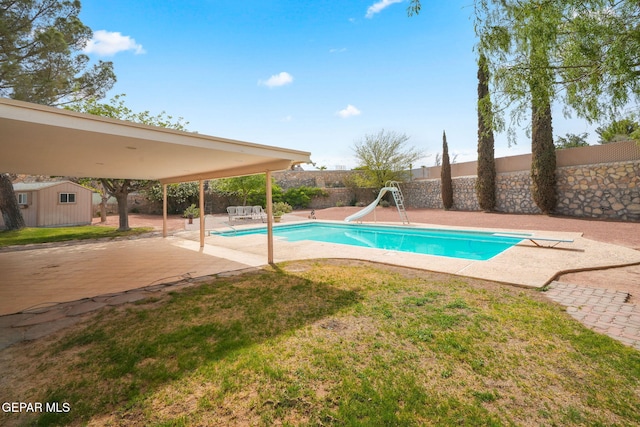 10601 Groverock Ct, El Paso, TX 79935 - view of swimming pool featuring a patio, a water slide, an outbuilding, and a diving board