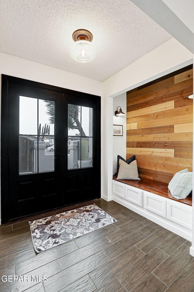840 Tepic Dr, El Paso, TX 79912 - mudroom with a textured ceiling, healthy amount of natural light, wooden walls, and dark wood finished floors