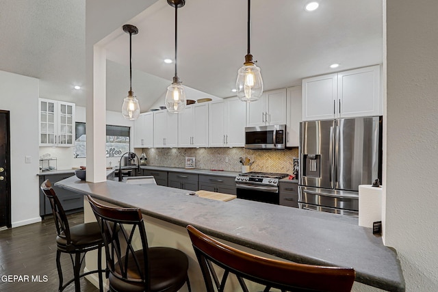 840 Tepic Dr, El Paso, TX 79912 - kitchen with stainless steel appliances, backsplash, a sink, white cabinetry, and vaulted ceiling