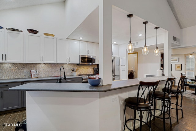 840 Tepic Dr, El Paso, TX 79912 - kitchen featuring appliances with stainless steel finishes, washer / dryer, dark countertops, dark wood-style flooring, and lofted ceiling