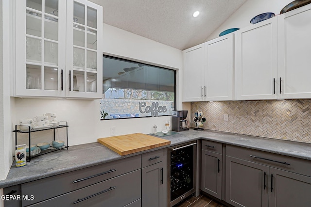 840 Tepic Dr, El Paso, TX 79912 - kitchen featuring wine cooler, tasteful backsplash, vaulted ceiling, gray cabinets, and glass insert cabinets