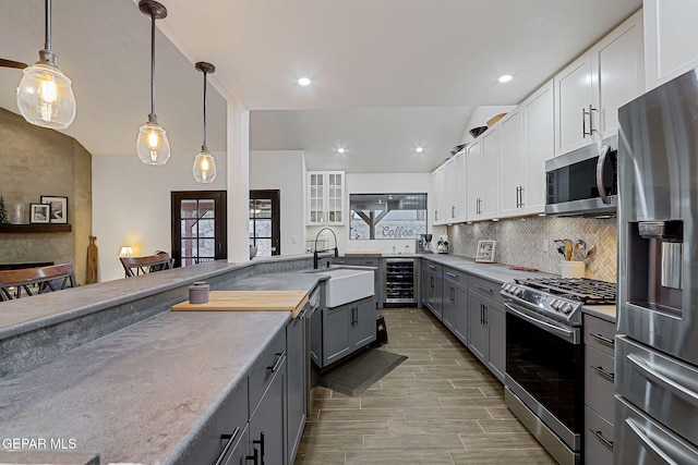 840 Tepic Dr, El Paso, TX 79912 - kitchen with stainless steel appliances, a sink, gray cabinets, backsplash, and beverage cooler