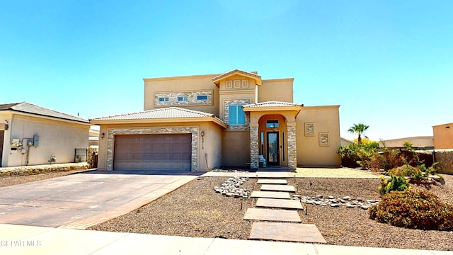 5712 Valley Lilac Ln, El Paso, TX 79932 - mediterranean / spanish-style house featuring stucco siding, a garage, driveway, a tile roof, and stone siding