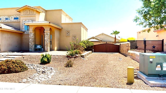 5712 Valley Lilac Ln, El Paso, TX 79932 - view of front facade with a gate, stucco siding, and stone siding