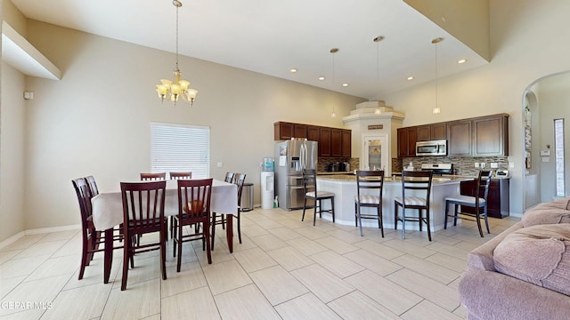 5712 Valley Lilac Ln, El Paso, TX 79932 - dining area with a high ceiling, a chandelier, arched walkways, recessed lighting, and baseboards