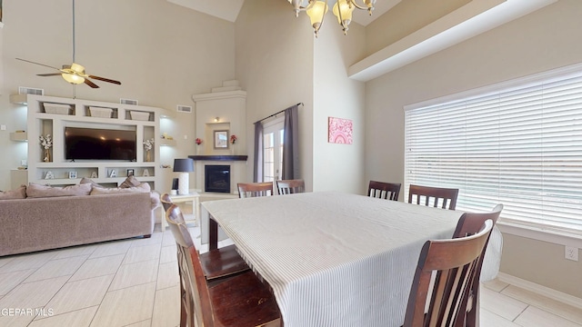 5712 Valley Lilac Ln, El Paso, TX 79932 - dining room with plenty of natural light, ceiling fan, a chandelier, a high ceiling, and a glass covered fireplace