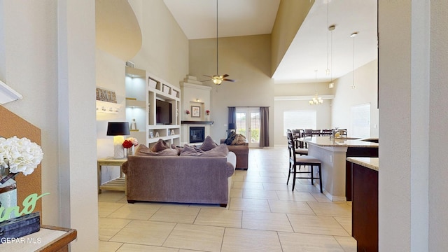 5712 Valley Lilac Ln, El Paso, TX 79932 - living room with a high ceiling, a ceiling fan, a glass covered fireplace, and light tile patterned floors