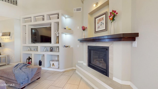 5712 Valley Lilac Ln, El Paso, TX 79932 - living area featuring a tile fireplace, built in shelves, and baseboards