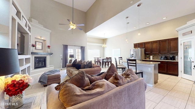 5712 Valley Lilac Ln, El Paso, TX 79932 - living room with a high ceiling, ceiling fan, a glass covered fireplace, light tile patterned floors, and recessed lighting