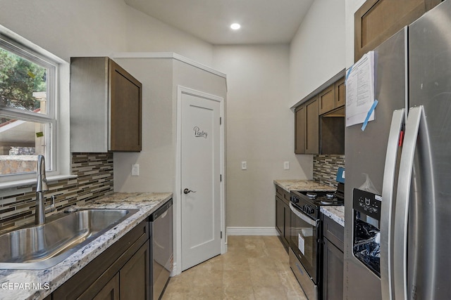 1718 Dean Jones Dr, El Paso, TX 79936 - kitchen featuring appliances with stainless steel finishes, a sink, tasteful backsplash, light stone counters, and recessed lighting