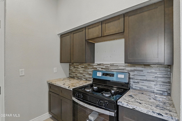1718 Dean Jones Dr, El Paso, TX 79936 - kitchen with range with gas stovetop, dark brown cabinets, baseboards, and tasteful backsplash