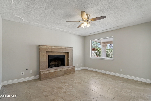 1718 Dean Jones Dr, El Paso, TX 79936 - unfurnished living room with a textured ceiling, a ceiling fan, a tile fireplace, and baseboards