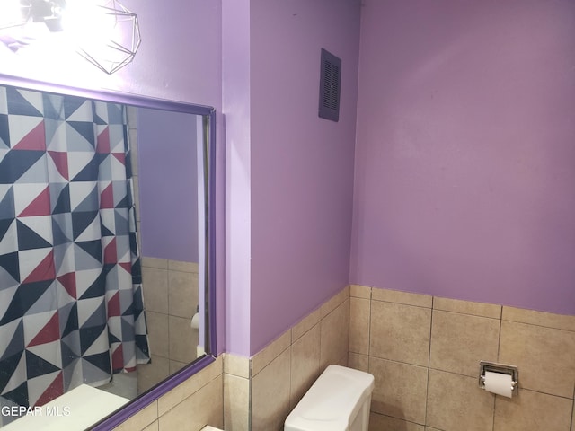 10173 Lakeview Dr, El Paso, TX 79924 - full bath featuring toilet, curtained shower, tile walls, and a wainscoted wall