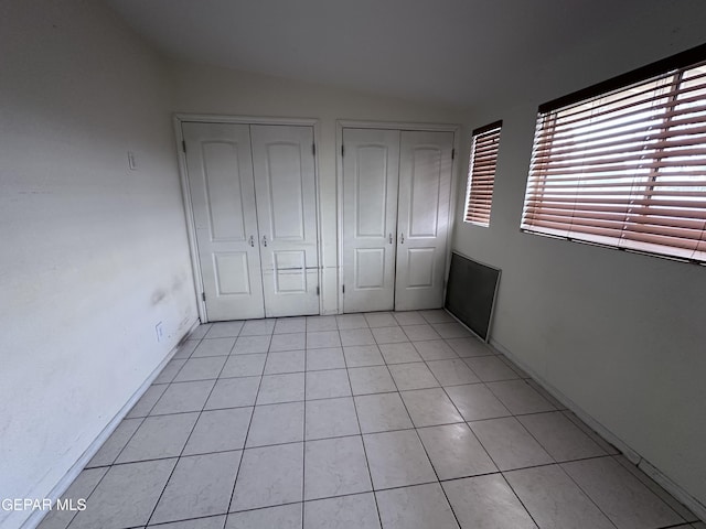 5403 Raymond Telles Rd, El Paso, TX 79924 - unfurnished bedroom featuring lofted ceiling, multiple closets, and light tile patterned flooring
