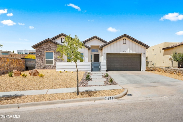 7467 Cimarron Gap Dr, El Paso, TX 79911 - ranch-style house with board and batten siding, an attached garage, concrete driveway, and stone siding