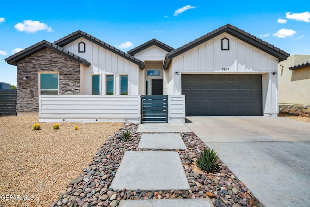 7467 Cimarron Gap Dr, El Paso, TX 79911 - single story home featuring board and batten siding, an attached garage, concrete driveway, a tiled roof, and stone siding