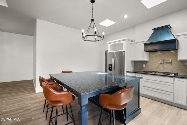 7467 Cimarron Gap Dr, El Paso, TX 79911 - kitchen featuring stainless steel appliances, custom range hood, a chandelier, a center island, and decorative backsplash