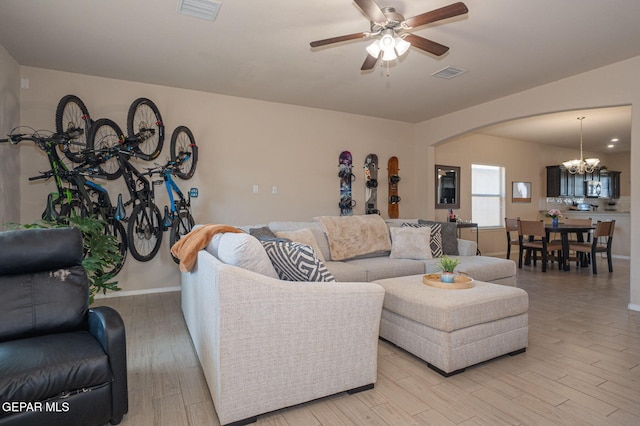 2221 Furtherpoint Pl, El Paso, TX 79911 - living room with a chandelier, arched walkways, a ceiling fan, and light wood finished floors