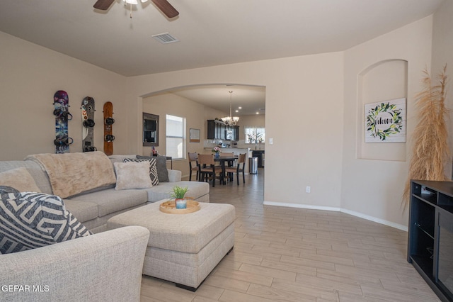 2221 Furtherpoint Pl, El Paso, TX 79911 - living area featuring a chandelier, arched walkways, ceiling fan, baseboards, and light wood finished floors