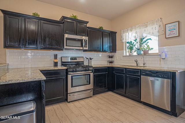 2221 Furtherpoint Pl, El Paso, TX 79911 - kitchen with appliances with stainless steel finishes, a sink, light stone counters, and light wood-type flooring