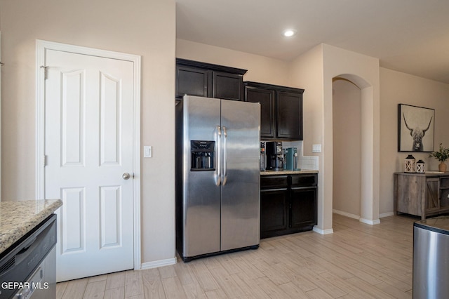 2221 Furtherpoint Pl, El Paso, TX 79911 - kitchen with stainless steel fridge, light wood finished floors, arched walkways, light stone countertops, and recessed lighting