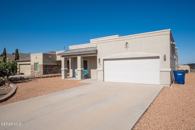 2221 Furtherpoint Pl, El Paso, TX 79911 - pueblo revival-style home featuring stucco siding, concrete driveway, and a garage