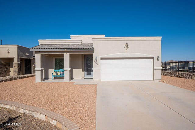 2221 Furtherpoint Pl, El Paso, TX 79911 - view of front facade featuring a tile roof, concrete driveway, a garage, stucco siding, and a porch