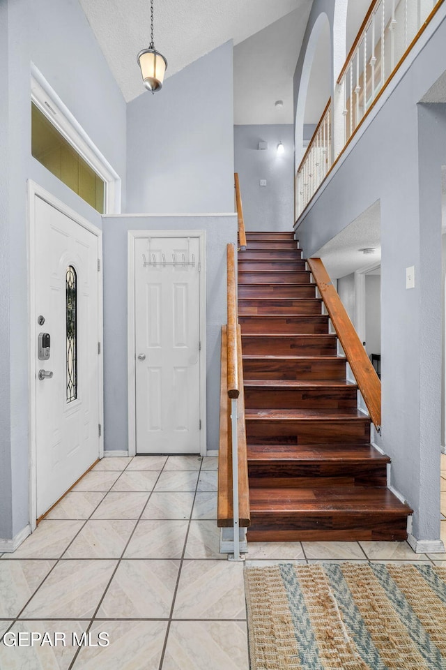 1640 Dennis Babjack Dr, El Paso, TX 79936 - tiled foyer entrance featuring a high ceiling, stairway, and baseboards